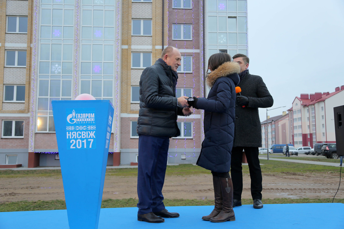 Виталий Маркелов вручает подарочный набор ключей от новой квартиры счастливым новоселам